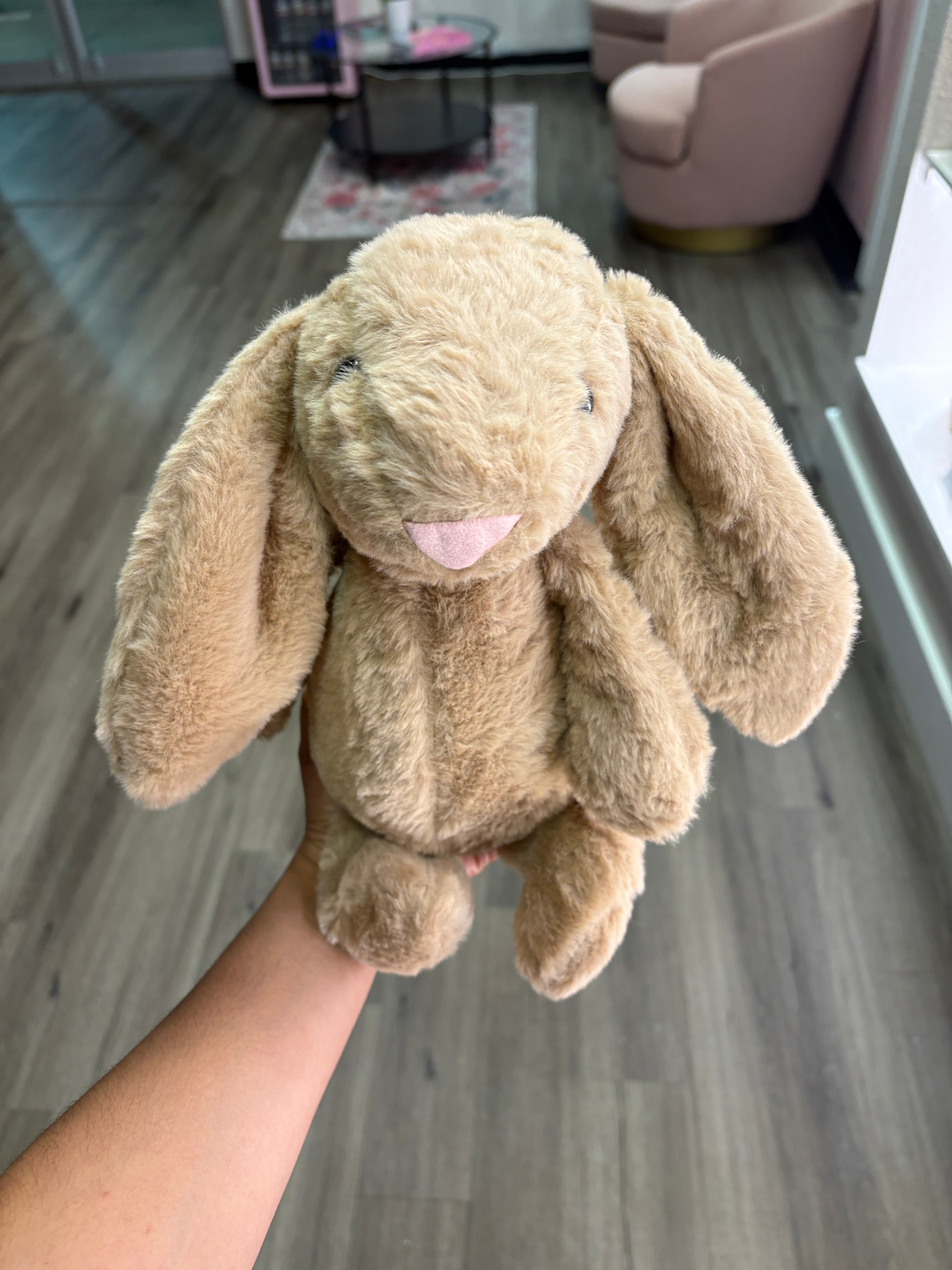 Brown bunny with bow on ears inserted in bouquet